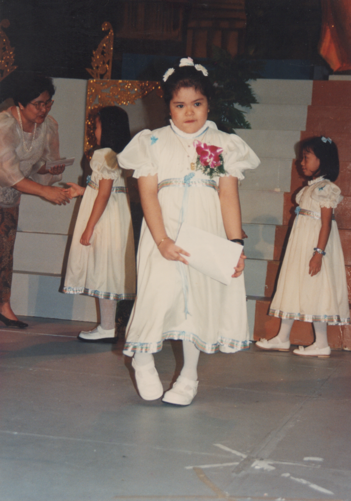 A young girl with clubfoot walks during school graduation.